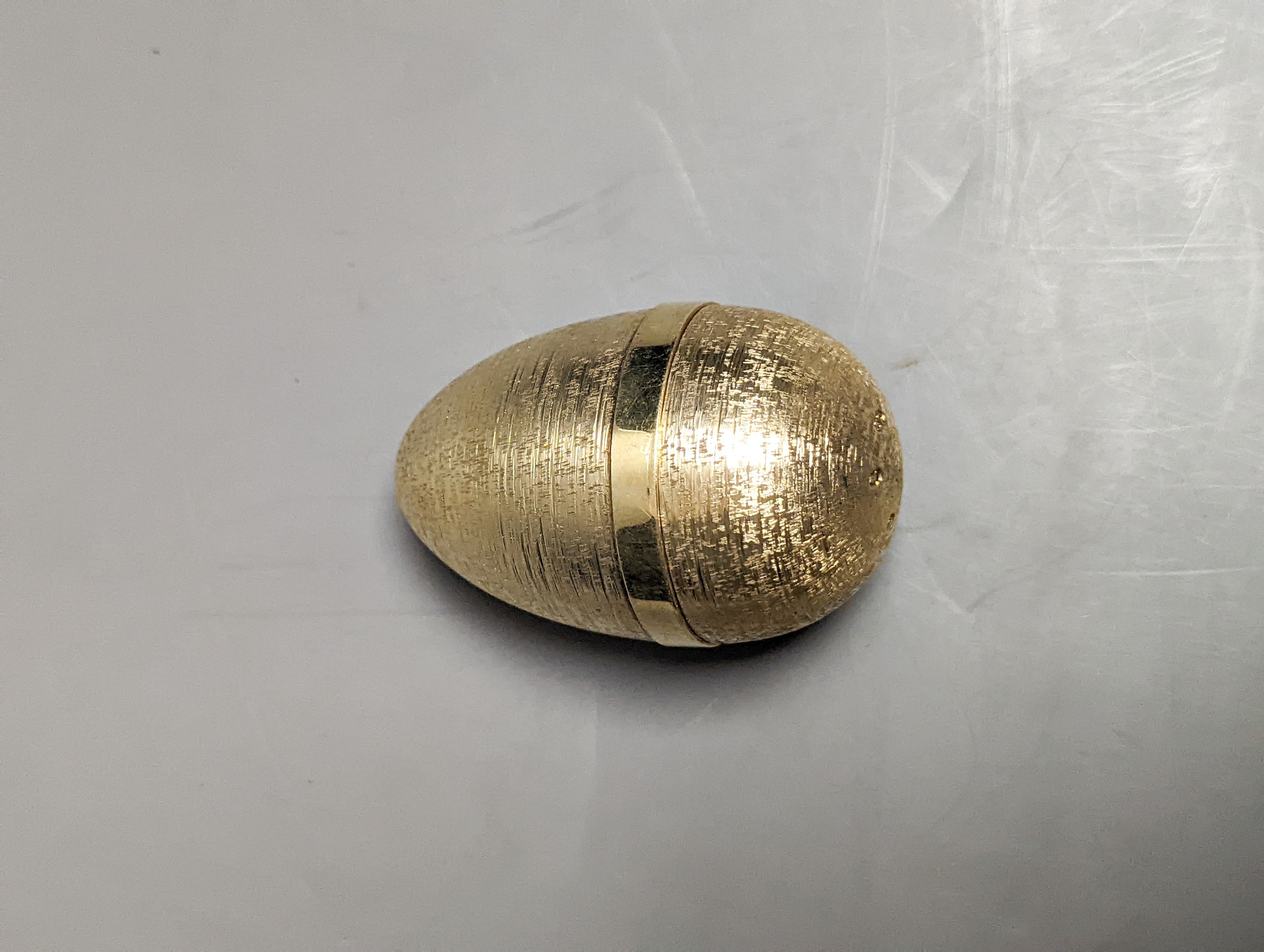 A 1970's textured silver gilt surprise egg by Stuart Devlin, opening to reveal a ship's anchor with fish, London, 1977, 71mm, no box or certificate.